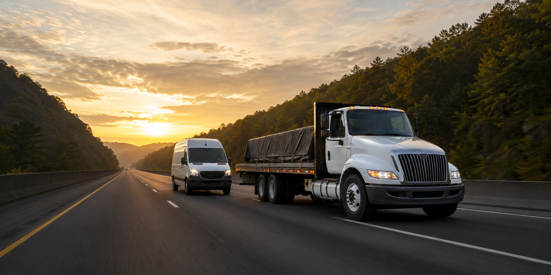 A 26-foot flatbed truck and Sprinter van traveling on an interstate